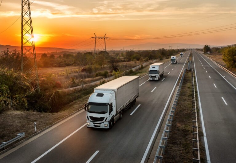 Trucks on a highway at sunset
